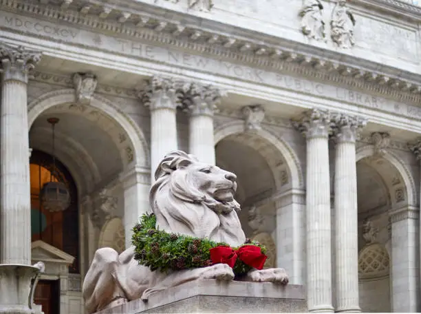 Photo of statue of the lion in the new york library decorated for christmas