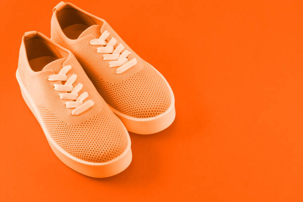 istock Bright orange sneakers on a bright orange background. 1049508918