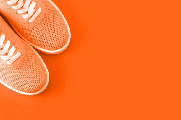istock Bright orange sneakers on an orange background. 1049509148