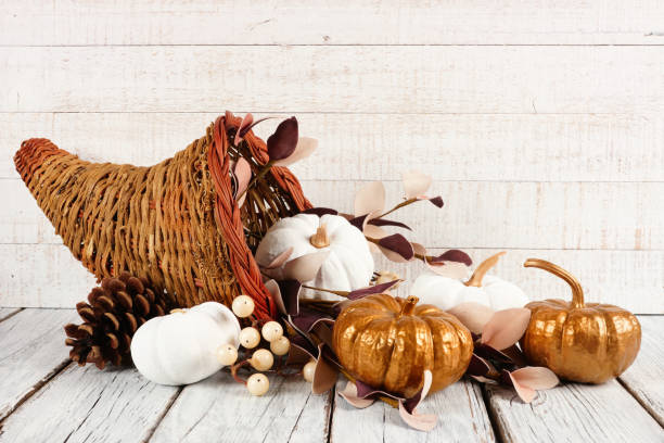 istock Thanksgiving cornucopia with white and gold pumpkins against white wood 1049510104