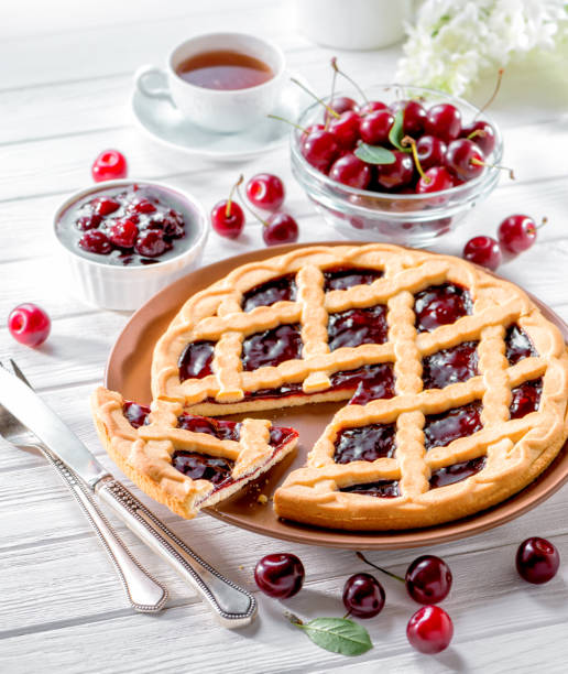 вишневый пирог на белом деревянном фоне подается со свежими ягодами - flower cherry cup tea стоковые фото и изображения