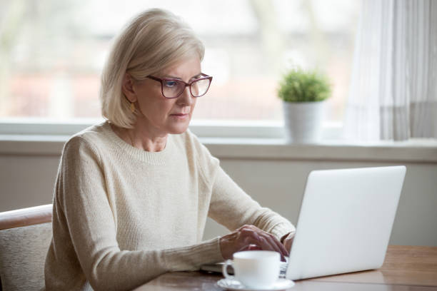istock Serious mature middle aged business woman using laptop typing email 1049512650