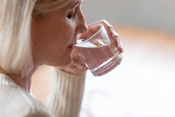 istock Dehydrated healthy senior woman feeling thirsty drinking water, hydration concept 1049512690