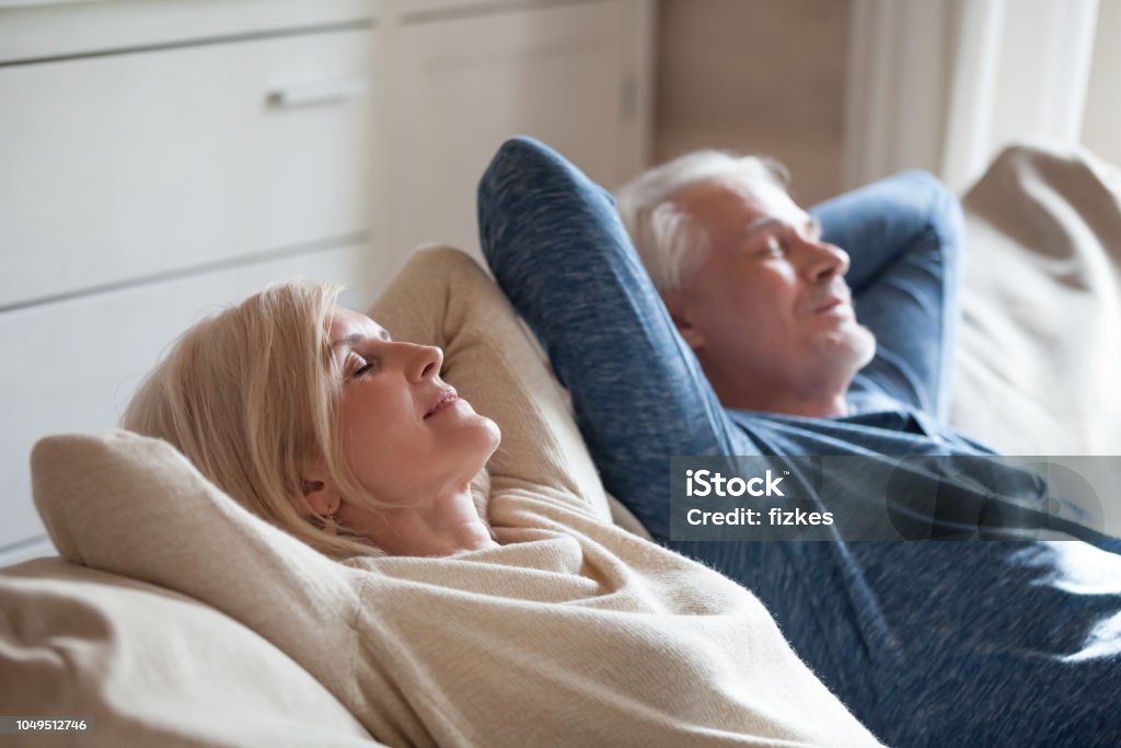 Pareja tranquila relajante en el sofá después de haber durante el día la siesta juntos - Foto de stock de Relajación libre de derechos