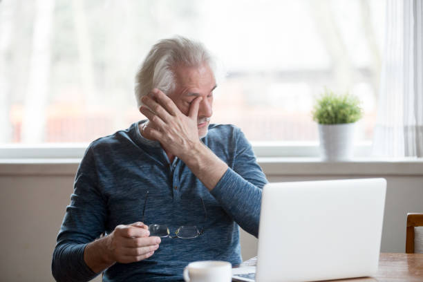 istock Fatigued mature man taking off glasses suffering from tired eyes 1049512806