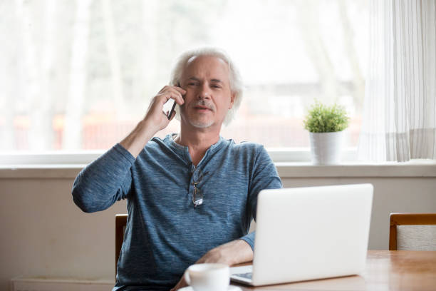 istock Senior mature man talking on phone making call at home 1049512812