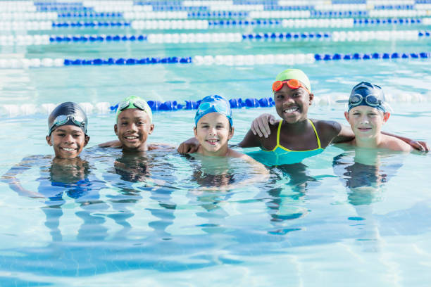 istock Multi-ethnic children in swimming pool smiling at camera 1049513712
