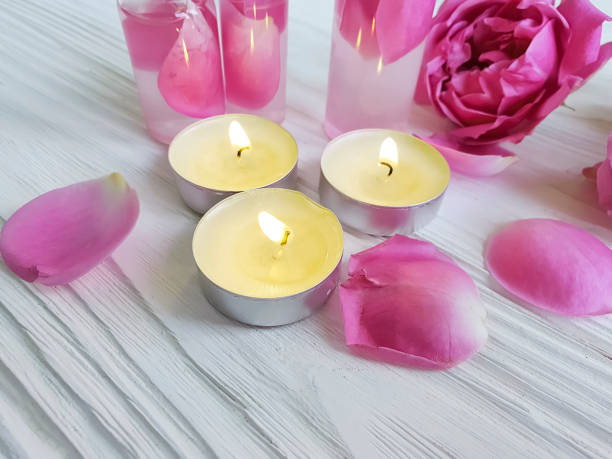 istock rose, extract, candle on a pink wooden background 1049513764