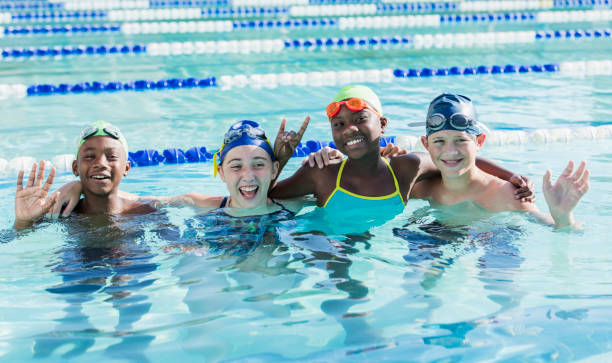 istock Multi-ethnic children in swimming pool smiling at camera 1049514940