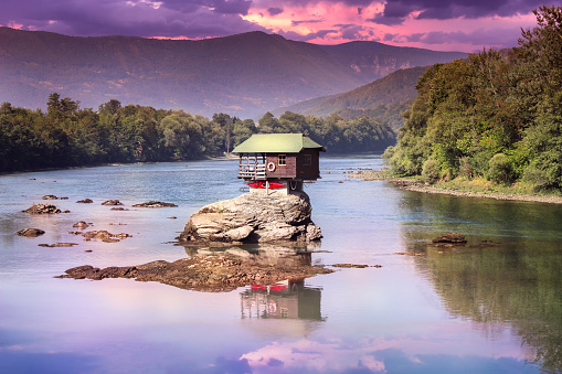 Drina house dramatic sunset and reflection - Colorful little house on the rock on the middle of the Drina river in west Serbia, one of the most popular attractions of this area