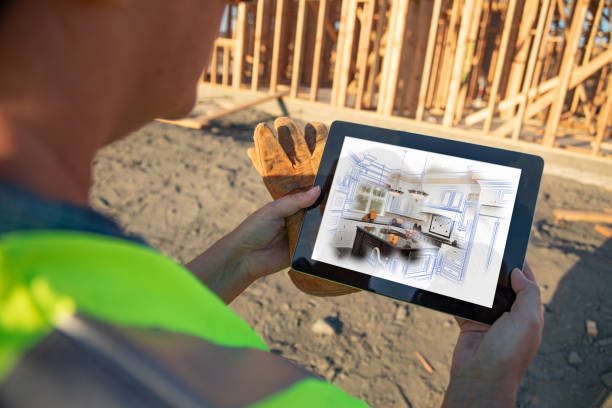 istock Female Construction Worker Reviewing Kitchen Illustration on Computer Pad at Construction Site 1049517146