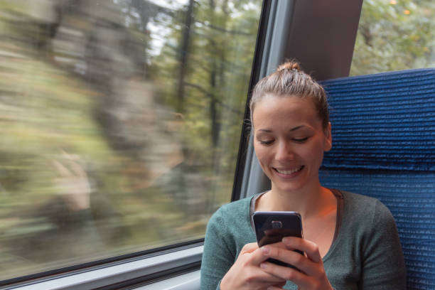 istock young woman text messaging with his smartphone during a journey in the train while she is going to work 1049518832