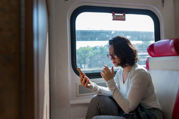 istock Worried woman talking on the phone inside the train 1049524042