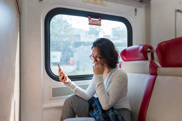 istock Worried woman talking on the phone inside the train 1049524062