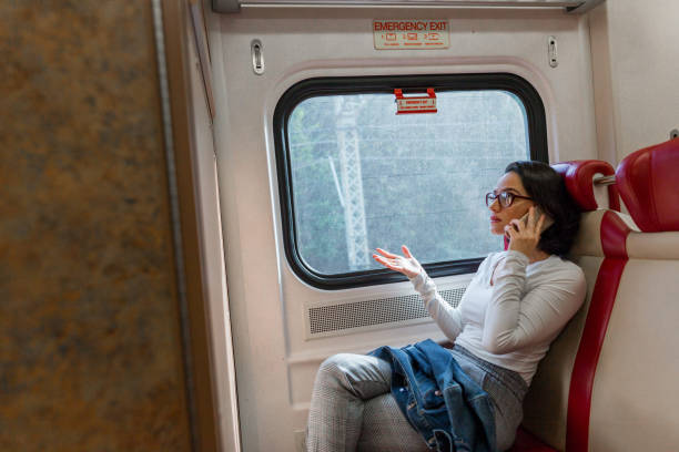 istock Frightened woman talking on the phone inside the train 1049524088