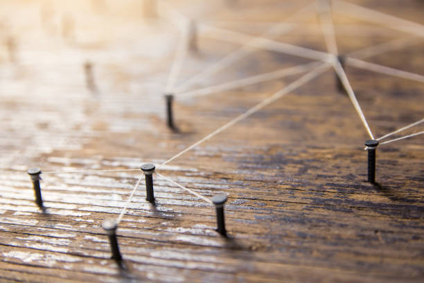 istock Connecting networks concept - network connected with yarn white on Plank wood with copy space. Simulator connection social media, internet, people communication, Linking entities 1049543302