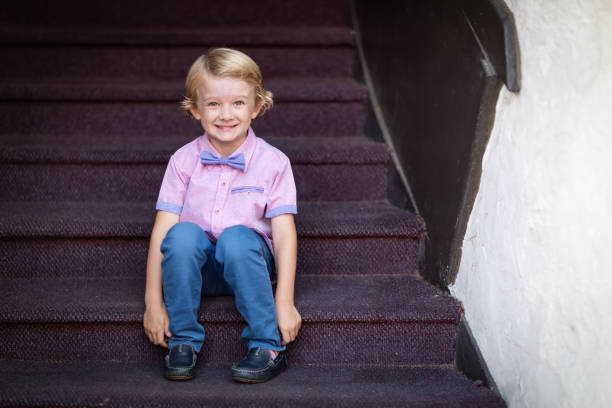 Cute Young Caucasian Boy Portrait Sitting On Stair Steps.