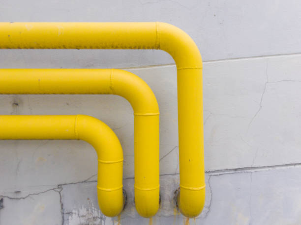 istock yellow gas pipe in front of building wall. 1049546028