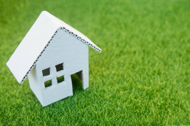 istock Eco house concept : Cardboard cut house on green grass with copy space 1049548744