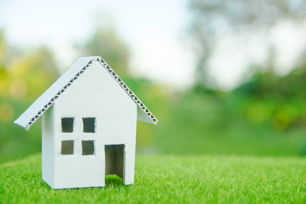 istock Eco house concept : Cardboard cut house on green grass with copy space 1049551130