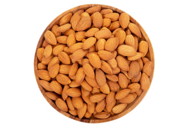 istock Almonds in wooden dish on white background. 1049560206