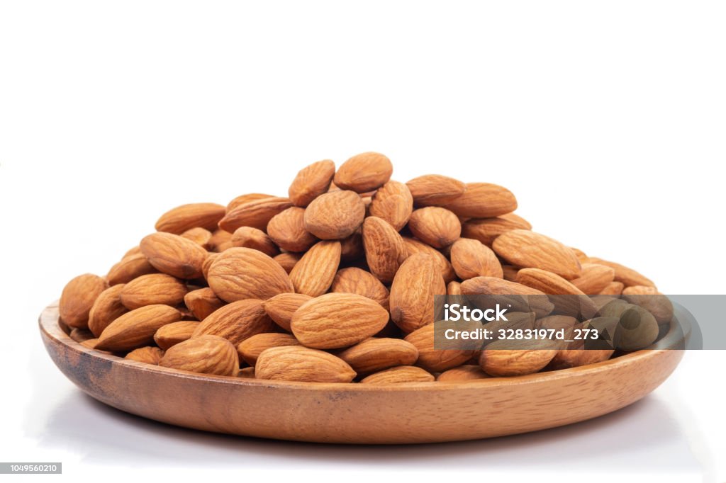 Almonds in wooden dish on white background. Almond Stock Photo