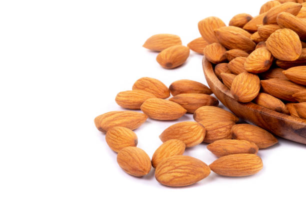 istock Almonds in wooden dish on white background. 1049560226