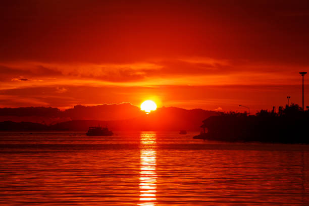 istock Sun setting in between silhouette mountain range and islands, Thailand famous place called Koh-Loy at Chonburi, shot taken by using long exposure technic therefore smooth water surface like mirror 1049576202