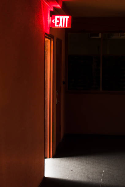 istock red exit sign board with light coming out of the door 1049579340