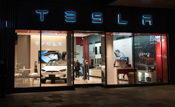 capitânia de carros tesla inc armazenar em chengdu china com logotipo de tesla e um modelo de carro elétrico x dentro - tesla - fotografias e filmes do acervo