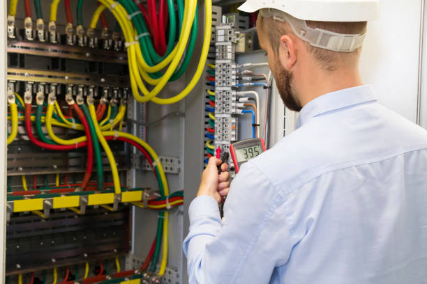 istock Electrician engineer at work inspecting cabling connection of high voltage power electric line in industrial distribution fuseboard. Service man with multimeter 1049592656