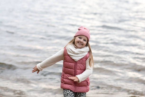 menina sorridente feliz divertindo feliz no outono ao ar livre - child praying beach little girls - fotografias e filmes do acervo