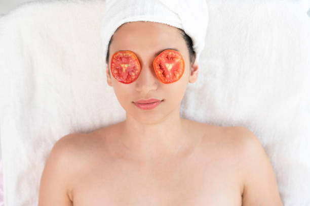 istock Woman getting eye nature treatment by tomato. 1049594968