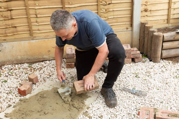 istock construction man laying and cementing clay bricks making a garden seat 1049598218