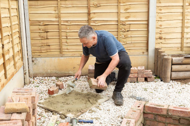 istock construction man laying and cementing clay bricks making a garden seat 1049598224