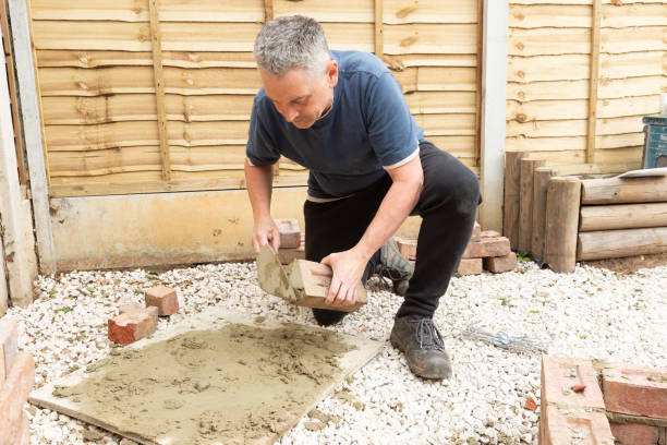 istock construction man laying and cementing clay bricks making a garden seat 1049598230