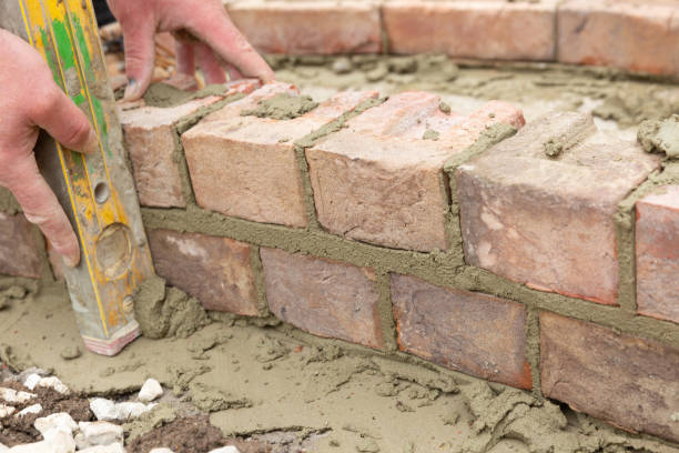 istock laying clay bricks with fresh wet cement to make a garden seat construction 1049598816