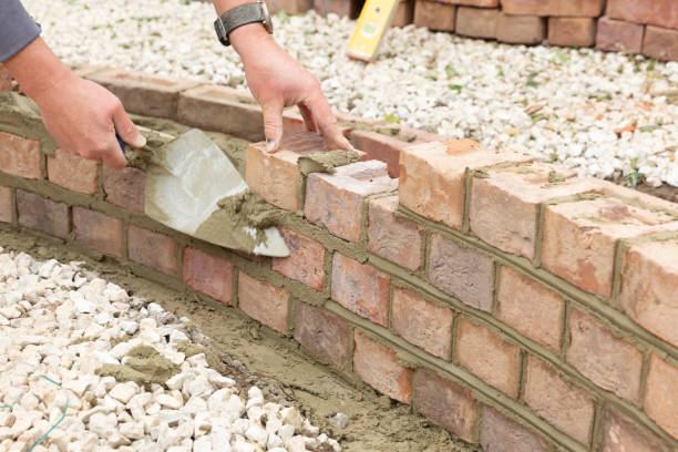 istock laying clay bricks with fresh wet cement to make a garden seat construction 1049598852