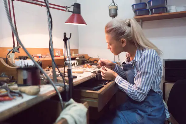 Female jeweller working late at her workshop.
