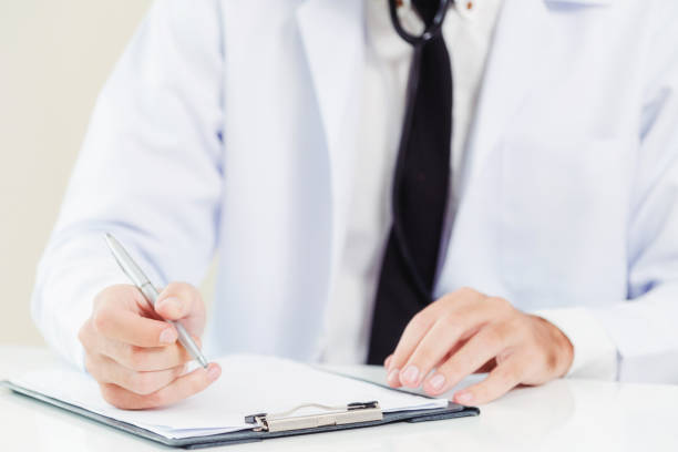 istock Doctor in hospital writing on a paper document. 1049601922