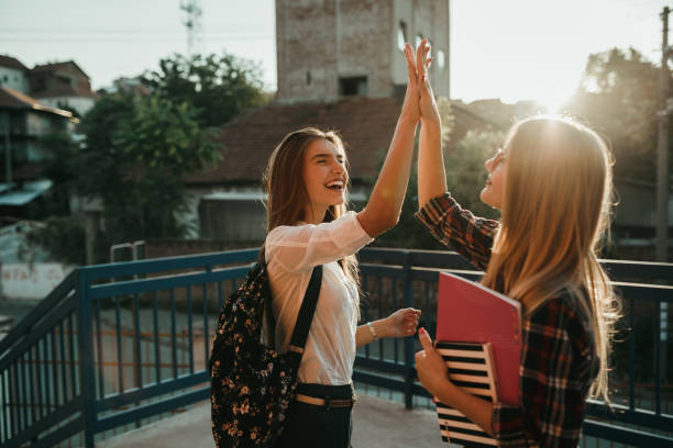 affascinanti studentesse adolescenti che festeggiano nel cortile della scuola - studente di scuola secondaria allievo foto e immagini stock