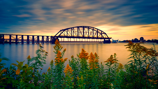 Golden sunset and clouds over Lake Superior with bridges and boat dock