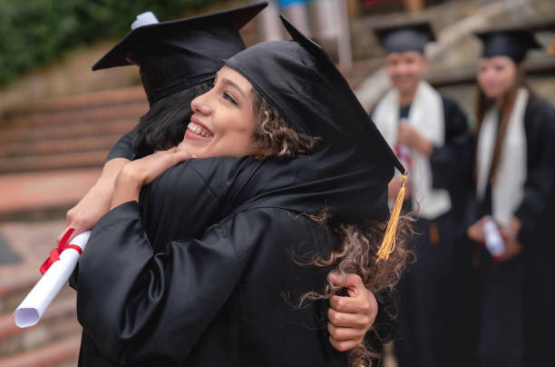 istock Happy students hugging and celebrating their graduation 1049624032