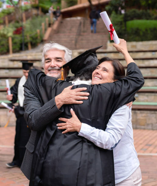 istock Proud parents hugging their son and celebrating his graduation 1049624088