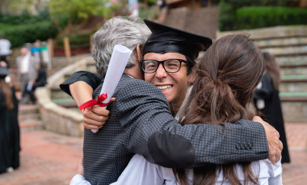 istock Proud parents hugging their son and celebrating his graduation 1049624098