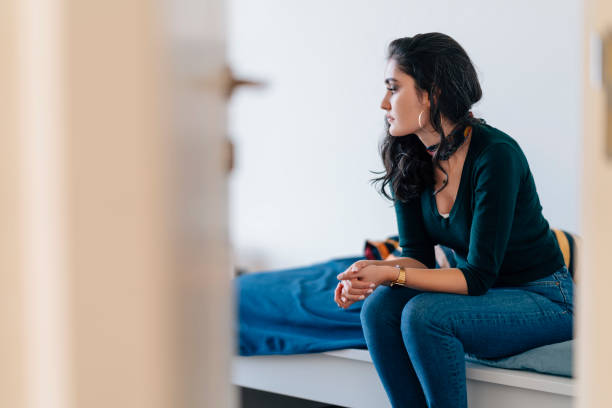 istock Lonely young woman sitting alone in room 1049635136