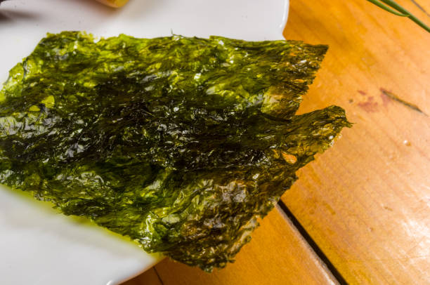 istock nori chips on a white ceramic plate, seaweed sheets 1049658524