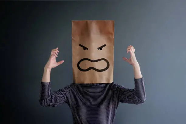 Photo of Customer Experience or Human Emotional Concept. Woman Covered her Face by Paper Bag and present Angry Feeling by Drawn Line Cartoon and Body Language