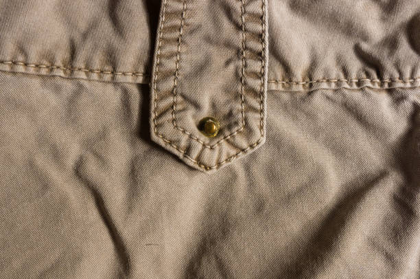 istock clothing items washed cotton fabric texture with seams, clasps, buttons and rivets 1049661876