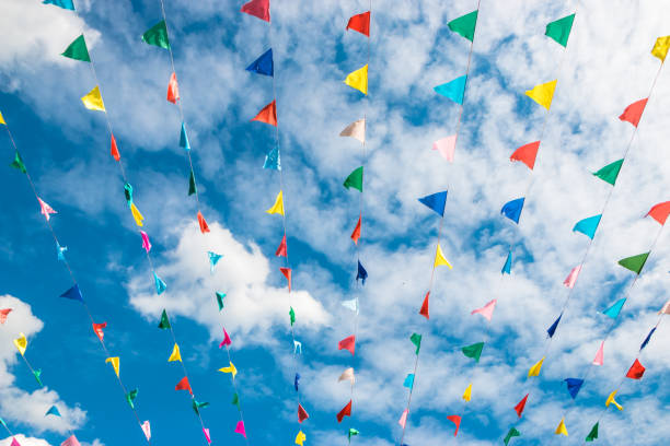 istock Multi-colored flags against a blue sky with clouds and a dome of a church. 1049680052
